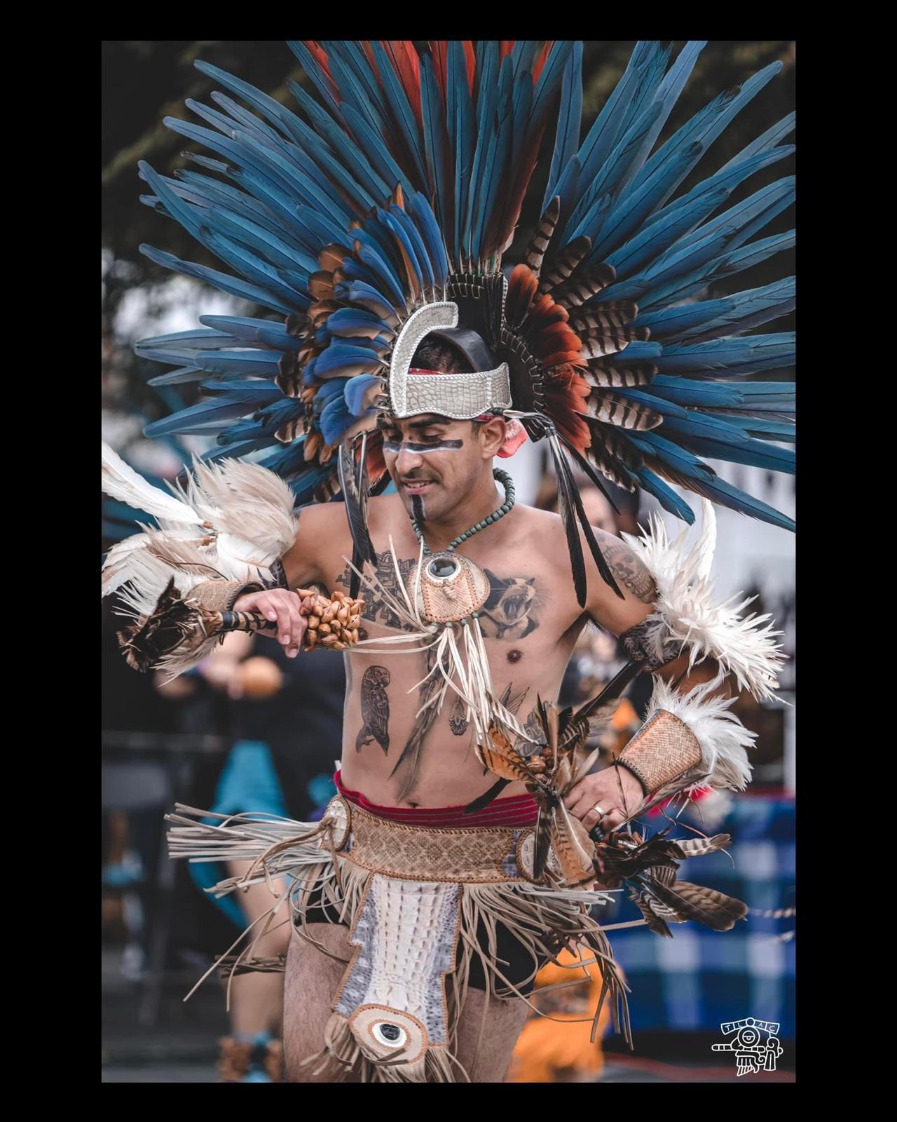 Aztec dancer with blue feathered headdress performing