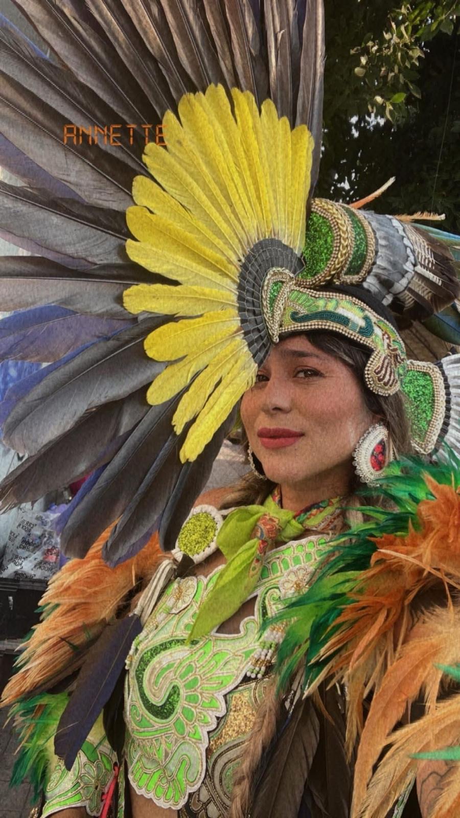 Dancer in green and yellow feathered regalia