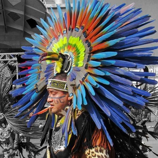 Aztec dancer with vibrant blue and orange feathered headdress