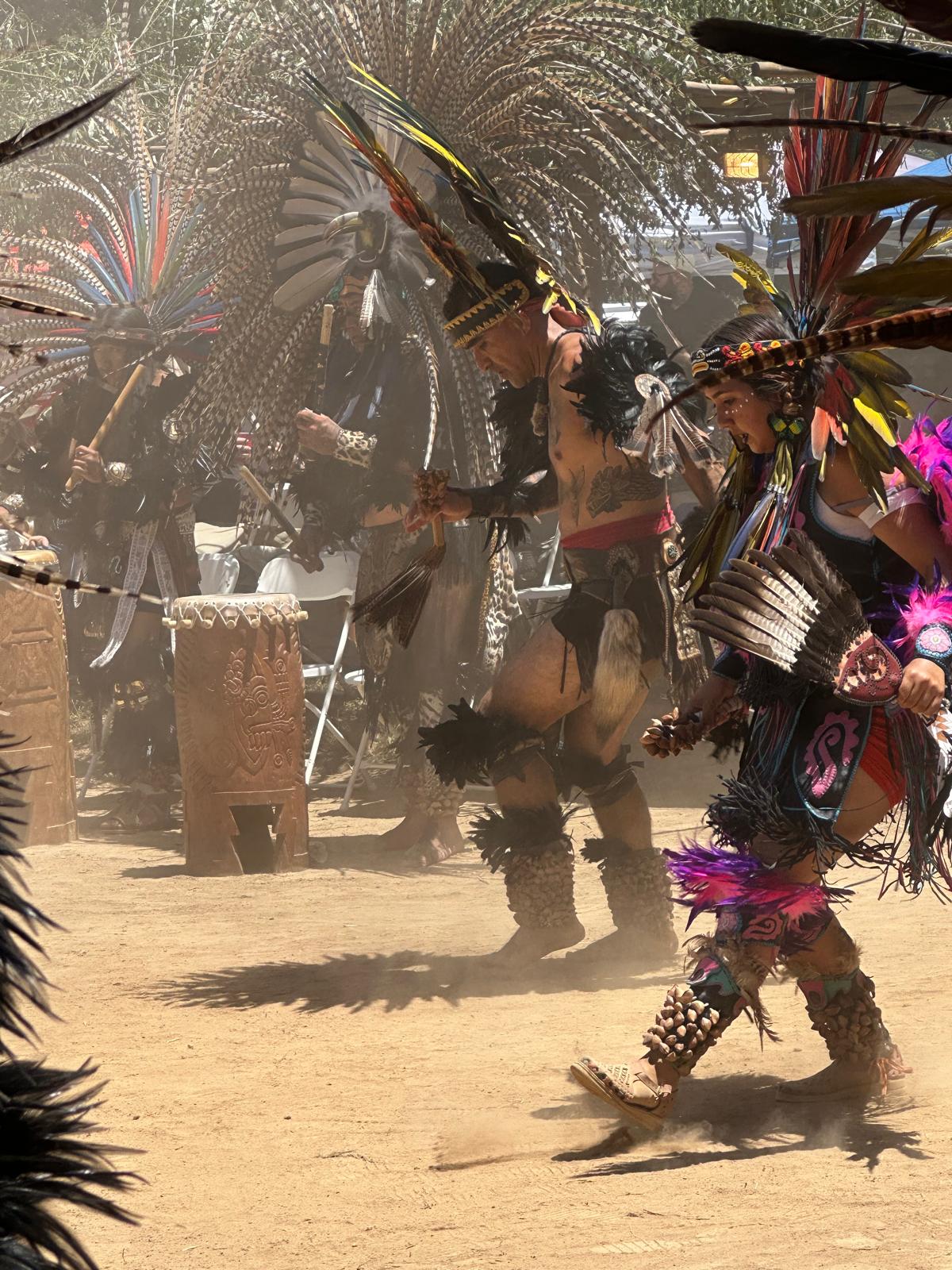 Aztec dancers performing in dusty ceremonial grounds